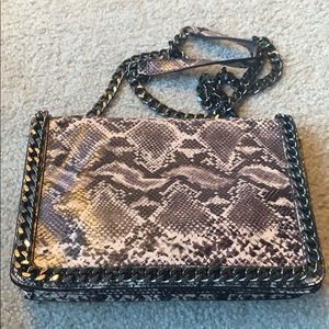 snakeskin clutch with black chain accessory